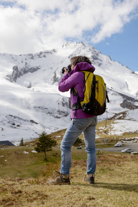 徒步旅行者相机和背包拍照的美丽山