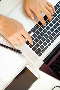 女性在笔记本电脑键盘上打字的手的特写镜头。女人的手
