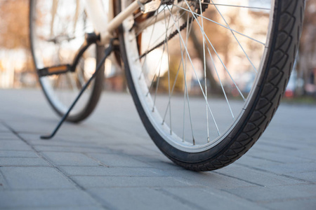 米色自行车轮子站立在人行道瓷砖在小巷