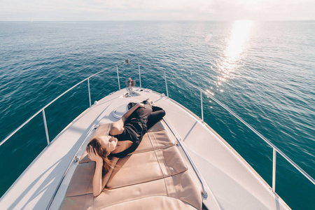 一个苗条的年轻女孩躺在她的白色游艇, 旅行加勒比海, 放松