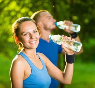 男人和女人的饮用水瓶后健身体育锻炼