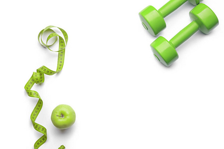 组合与哑铃, 测量磁带和苹果在白色背景, 顶部视图。健身房锻炼