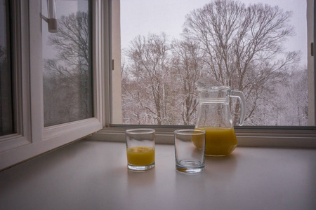 两个杯子和一壶部分装满橙汁