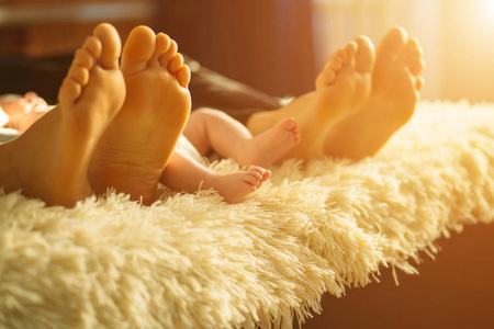 家庭躺在床上, 他们的英尺集中。母亲, 父亲和新生的婴孩儿子