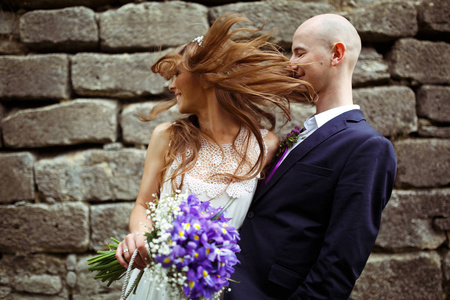 新郎抱着新娘，虽然她玩弄她的头发图片
