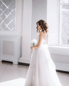美丽的新娘与花束在白色大厅里