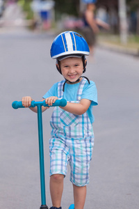 快乐的小男孩，头戴头盔，玩弄他的机车户外
