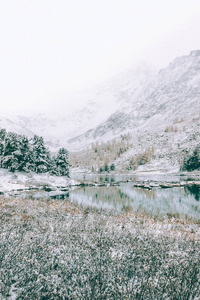 山湖寒冷的早晨。岩石上湖岸边的积雪