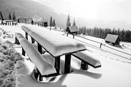 桌子和板凳后暴雪被新鲜的雪覆盖着