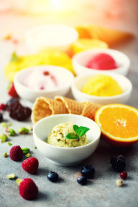 冰淇淋球在碗, 华夫饼锥, 浆果, 橙色, 芒果, 开心果在灰色的具体背景。五颜六色的汇集, 平的放置, 夏天概念