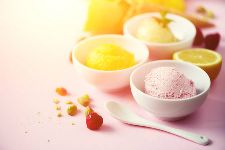 冰淇淋球在碗, 华夫饼锥, 浆果, 橙色, 芒果, 柠檬, 薄荷, 开心果在粉红色破旧别致的背景。丰富多彩的收藏, 夏日的概念
