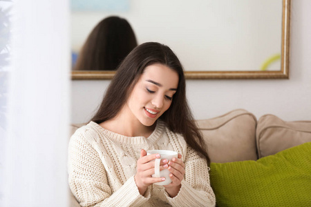 家中有杯热茶的美丽年轻女子