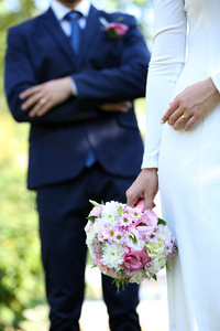 婚礼花束与自然背景上的新郎新娘