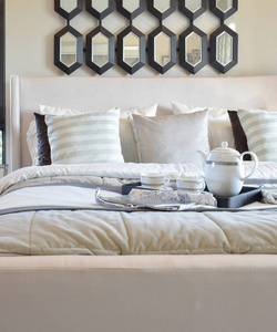 装饰黑色托盘的茶具在现代卧室的床上
