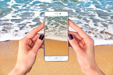 在海滩上的智能手机上拍照