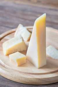 粒 Padano 奶酪在木板上