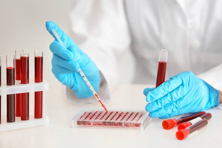 实验室工作人员将血液样本滴入试管