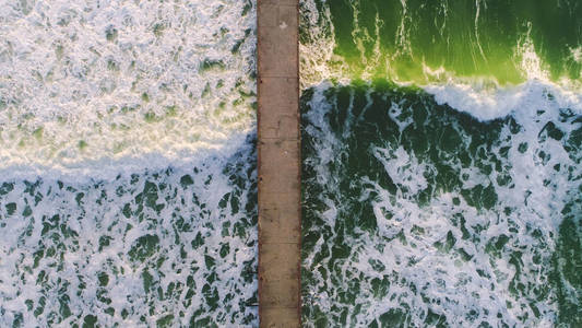 大绿海浪和旧断桥的鸟瞰图