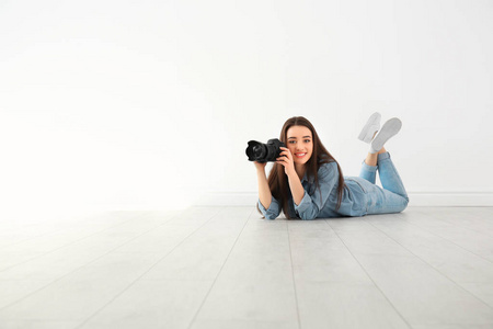 女摄影师与摄像头躺在地板室内