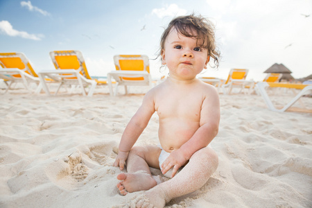 在墨西哥的阳光明媚的海滩上卷曲头发的男孩