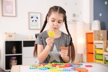 小孤独症女孩在家里玩拼图游戏