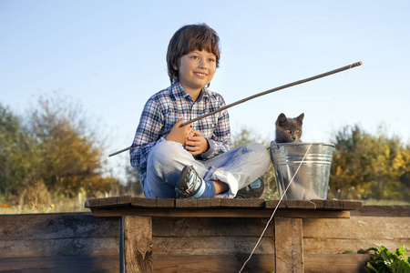快乐的小男孩在宠物 一个儿童和工具包河去钓鱼