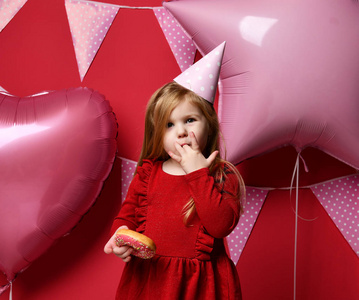 可爱的漂亮女孩与粉红色气球和红色礼物和生日帽