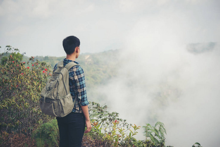 徒步旅行者背包站在山顶上欣赏自然美景