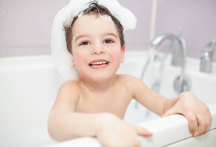 快乐有趣小男孩微笑在浴室里。洗澡