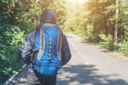 徒步旅行者的后方步行在农村道路上度假。假期