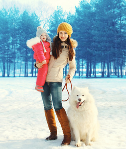 家庭在冬季公园 快乐妈妈和行走与白色的孩子