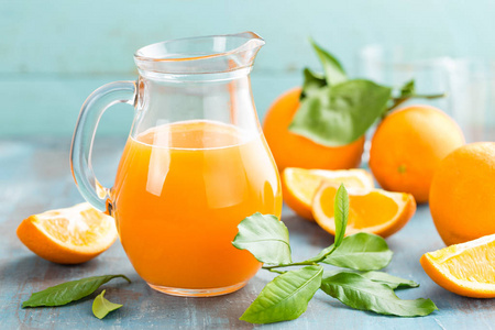 橙汁在玻璃和新鲜水果与叶对木制背景