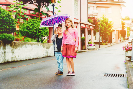 可爱的孩子们在户外玩得开心 玩雨下