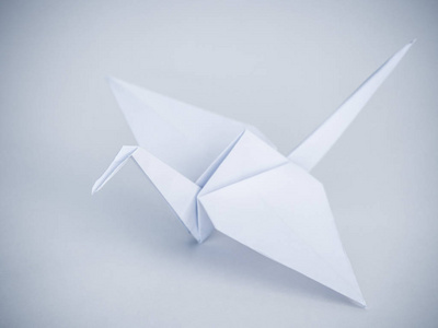 美丽的传统日本折纸起重机或 orizuru 白色折叠纸制作的白色背景