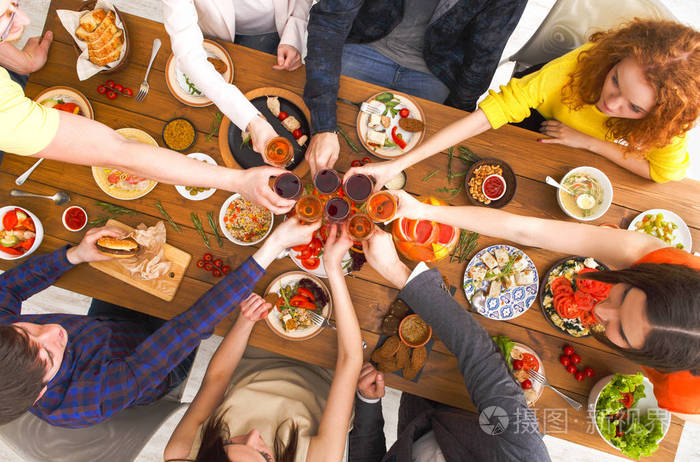 人们说在节日的餐桌宴会的欢呼声碰杯照片-正版商用图片0nj3ai-摄图新