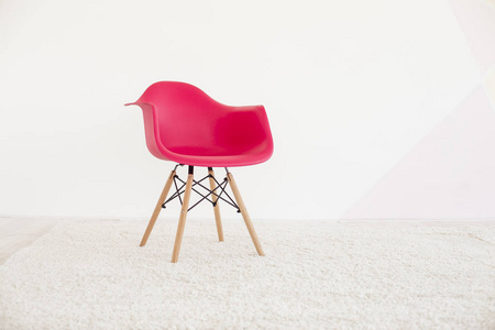 现代把红色的椅子。明亮的公寓，空的白墙，为您的文字