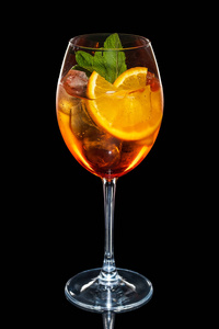 樱桃和橙色鸡尾酒与冰块在酒玻璃被隔绝在黑
