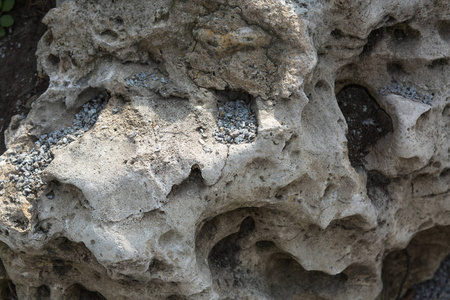 旧的纹理灰色石头与一个洞。特写片段