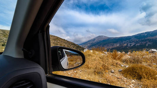 从在希腊, 克里特岛的道路上的汽车窗口的山景景观。旅行乘汽车