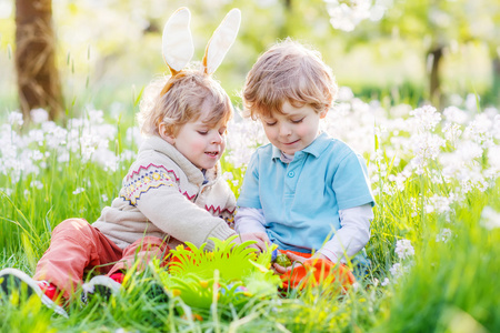 两个有趣的孩子朋友在复活节兔子耳朵期间蛋狩猎