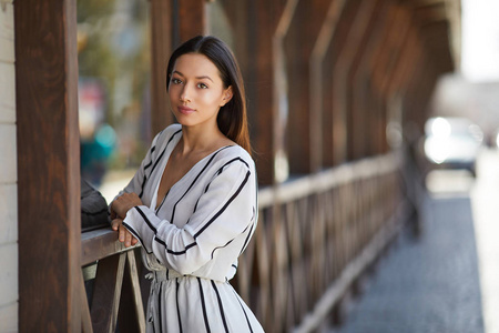 美丽的运动女孩站在附近的墙壁和姿势相机