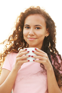 关闭了在喝咖啡在夏季露台的粉红色裙子的漂亮的年轻女人的画像