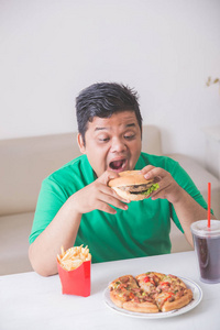 过度肥胖的男子吃垃圾食品图片
