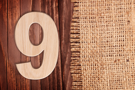 木制数字一个符号9。在木桌背景王氏麻布