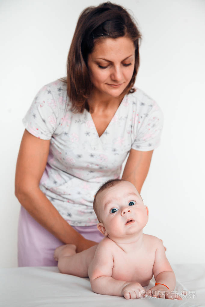 女医生给婴儿做背部按摩。儿童按摩