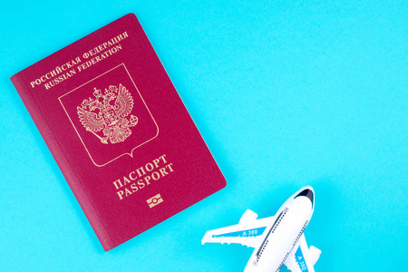 在蓝色背景上的飞机和红色俄罗斯护照。旅游理念