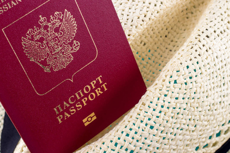 关闭红色俄罗斯护照在帽子。旅游理念