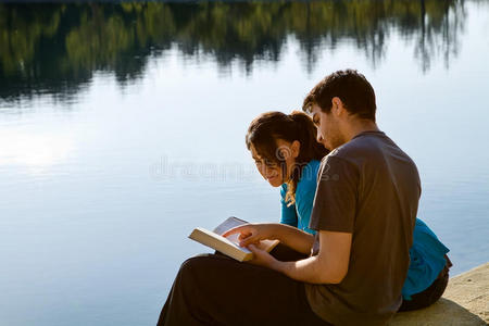 一对夫妇在湖边读圣经
