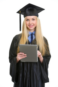 一位身着毕业礼服的微笑年轻女士使用平板电脑