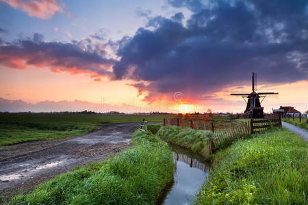 荷兰风车和河流上温暖的日出